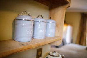 a group of white cups sitting on a shelf at Just a Minim - quaint studio in beautiful rural retreat in Rushford