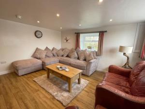 a living room with a couch and a table at The Old Dairy Accommodation in Tillingham