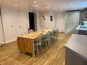 a large wooden table and chairs in a kitchen at The Old Dairy Accommodation in Tillingham