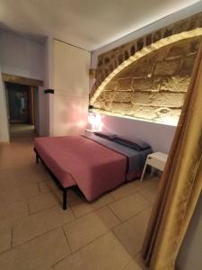 a bedroom with a bed and a brick wall at Il Cunicchio alloggio turistico al centro di Viterbo disponibile WiFi in Viterbo