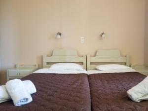 two beds sitting next to each other in a bedroom at MIRABELLO HOTEL APARTMENTS in Dassia