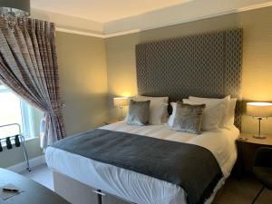 a bedroom with a large bed with two pillows at The Station Guest House in Brixham