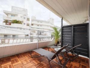 a balcony with chairs and a view of a building at CABIN&HOTEL CONSTANT NAHA in Naha