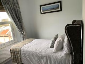 um quarto com uma cama e uma janela em The Station Guest House em Brixham