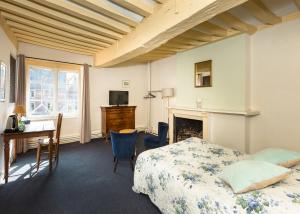 a bedroom with a bed and a desk and a fireplace at Auberge du Manoir d'Archelles in Arques-la-Bataille