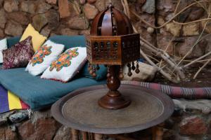 a wooden table with a lamp on a table with a couch at Alf Leila Boutique Hotel in Dahab