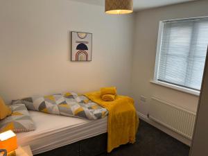 um quarto com uma cama com um cobertor em AMAZING 8 PERSON 3 BEDROOM 3 BATHROOM HOUSe em Hull