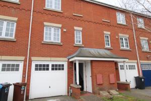 un edificio de ladrillo con dos puertas blancas de garaje en AMAZING 8 PERSON 3 BEDROOM 3 BATHROOM HOUSe, en Hull