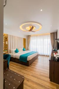 a bedroom with two beds and a chandelier at Hotel Yog Vashishth in Rishīkesh