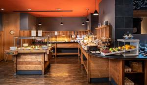 a large kitchen with a counter with food at mainhaus Stadthotel Frankfurt in Frankfurt +43 photos