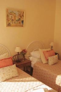 Un dormitorio con 2 camas y una mesa con lámparas. en El Cid Country Club, en Benidoleig