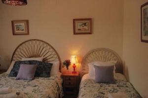 a bedroom with two beds and a table with a lamp at El Cid Country Club in Benidoleig