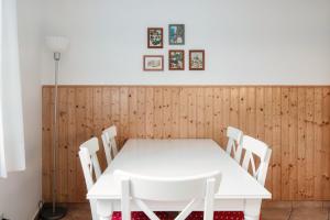 einen weißen Tisch und Stühle in einem Zimmer mit Holzwänden in der Unterkunft Casa Cigno by Quokka 360 - relaxation and sunshine assured in Minusio