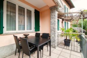 eine Terrasse mit einem Holztisch und Stühlen in der Unterkunft Casa Cigno by Quokka 360 - relaxation and sunshine assured in Minusio