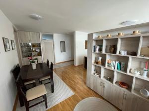een eetkamer en een woonkamer met een tafel en planken bij New Belgrade apartment in Belgrado