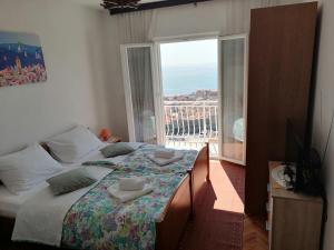 a bedroom with a bed and a large window at Guest House Blaise in Dubrovnik