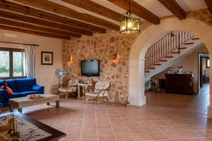 - un salon avec un canapé bleu et un escalier dans l'établissement Es Garrover, à Santanyí
