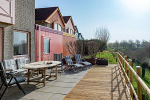 een houten terras met een tafel en stoelen op een huis bij Grasse 142 - Kustpark Village Scaldia in Hoofdplaat