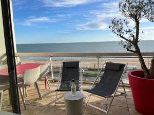 a balcony with two chairs and a table and the ocean at Malibu Beach LA BAULE appartement face à la mer ! in La Baule