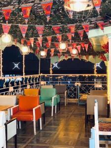 Town View Hotel في القاهرة: غرفة طعام مع كراسي ملونة وأعلام على السقف