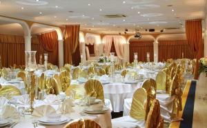 a large banquet room with white tables and yellow chairs at Berr Hotel in Istanbul