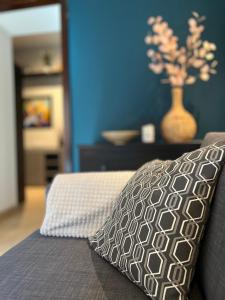 a pillow sitting on a bed with a blue wall at Templomvölgy Resort Mátrakeresztes in Matrakeresztes