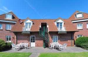 a brick building with tables and chairs in front of it at Ferienhaus Wattn Urlaub in Bensersiel