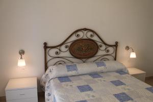 - une chambre avec un lit doté d'une grande tête de lit et de lumières dans l'établissement Luisa bilocale con giardino, à Castagneto Carducci