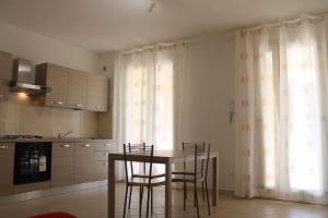 - une cuisine avec une table et des chaises dans la chambre dans l'établissement Luisa bilocale con giardino, à Castagneto Carducci