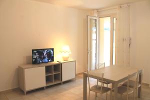 un salon avec une table à manger et une télévision dans l'établissement Luisa bilocale con giardino, à Castagneto Carducci