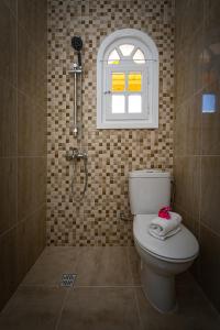 a bathroom with a toilet and a window and a shower at Porto Giardino Apartments in Kipseli