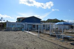 - un bâtiment sur la plage avec un parasol dans l'établissement Luisa bilocale con giardino, à Castagneto Carducci