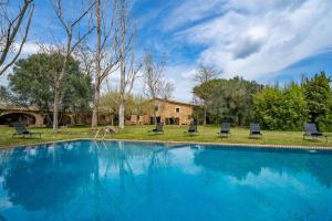 a swimming pool with chairs and a house at Masia Marco Lux, ideal familias con gran zona exterior y Piscina in Llagostera