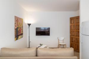 ein Wohnzimmer mit einem Sofa und einer Lampe in der Unterkunft BnS Triunfo Centro Suites in Granada