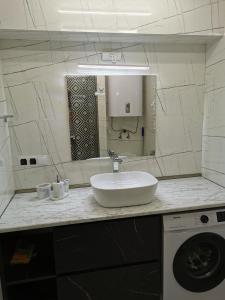 a bathroom with a sink and a washing machine at Orbi beach tower in Batumi