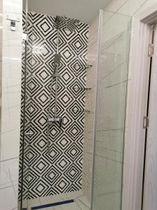 a shower with a glass door in a bathroom at Orbi beach tower in Batumi