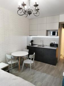uma cozinha com uma mesa e cadeiras e um lavatório em Orbi beach tower em Batumi