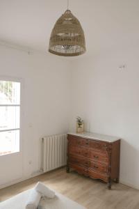a room with a wooden dresser and a chandelier at Villa Sa Caleta in Lloret de Mar