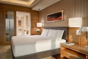 胡志明市的住宿－西貢洲際酒店，卧室配有一张白色大床和一张书桌