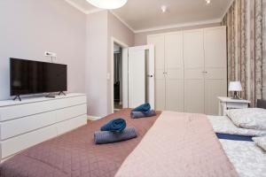 a bedroom with a large bed with two blue pillows on it at Urban Jungle apartment in the heart of the city in Białystok