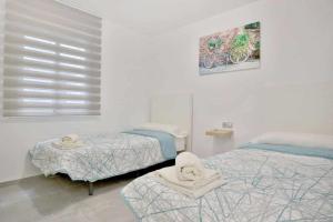 1 dormitorio con 2 camas individuales y una foto en la pared en Apartamento Paseo de La Ribera en Córdoba