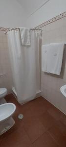 y baño con cortina de ducha blanca y aseo. en Guesthouse da Vila en Mourão
