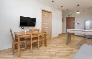 uma sala de jantar com uma mesa e uma televisão na parede em Urban Jungle - Vera Apartment em Bialystok