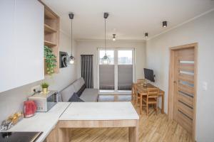 uma cozinha e sala de estar com uma mesa e uma secretária em Urban Jungle - Vera Apartment em Bialystok