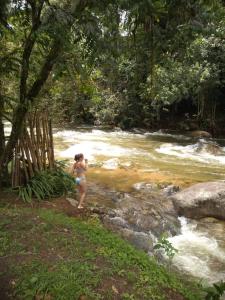 een vrouw in een bikini in een rivier bij Hospedagem Namastê in Visconde De Maua