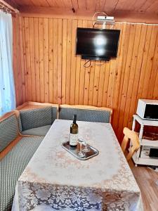 a table with a bottle of wine and a television at Boglári Harmónia Apartman in Balatonboglár
