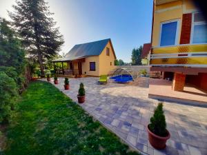 a patio with potted plants in front of a house at Boglári Harmónia Apartman in Balatonboglár