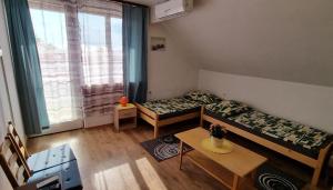 a room with two beds and a table and a window at Boglári Harmónia Apartman in Balatonboglár +29 photos