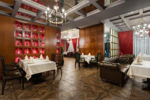 a dining room with tables and chairs and a chandelier at OSCAR BOUTIQUE HOTEL in Tashkent