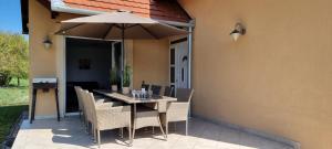 Balaton Villa في جينيسدياس: طاولة وكراسي مع مظلة على الفناء